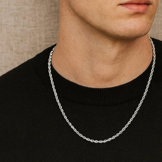 Silver chain necklace worn by a person on a neutral background