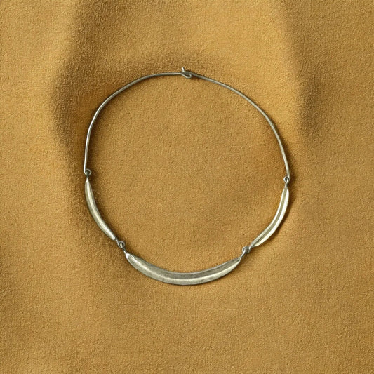 Silver necklace on a brown textured background