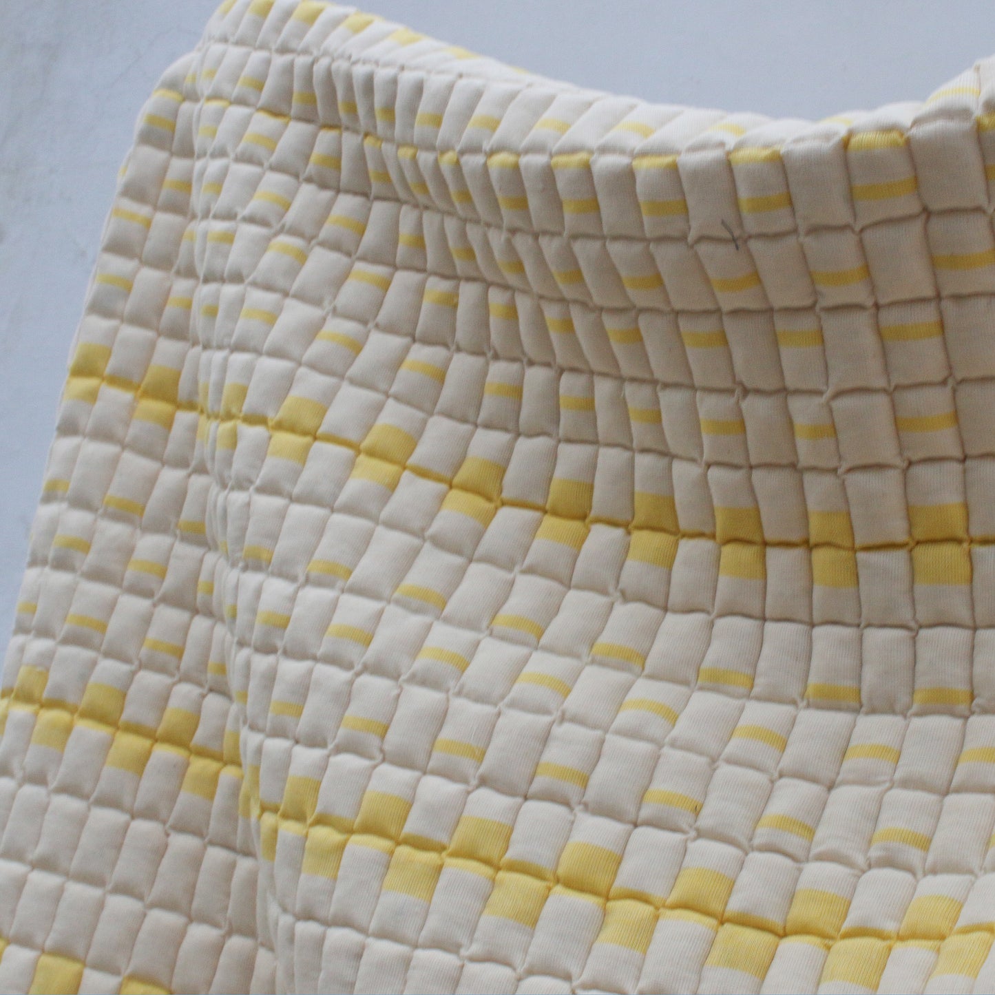 Håndbrodert Sujni-sengeteppe med geometrisk firkantmønster i varme røde og gule fargetoner.