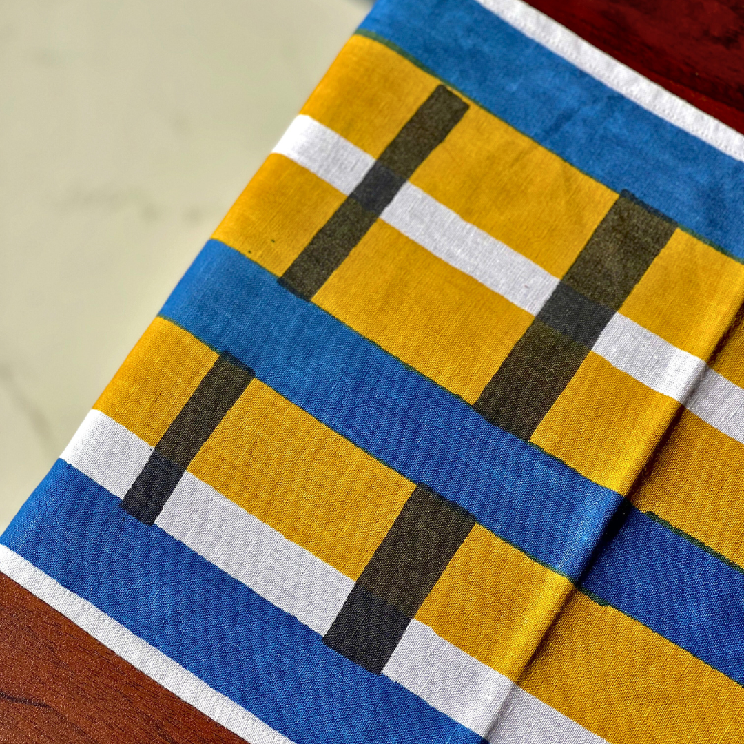 Et spisebord i tre stylet med en håndtrykket bordløper i økologisk bomull med geometrisk mønster.