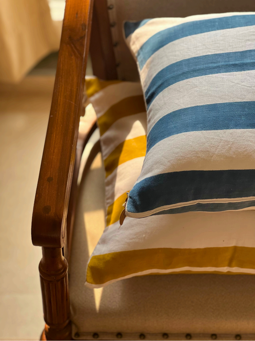 En lun sofa stylet med ulike håndlagde putetrekk med blomstrete blokktrykk og vevde teksturer.