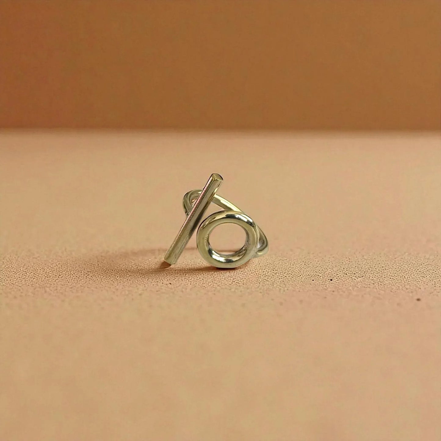 Silver ring with a unique design on a beige background