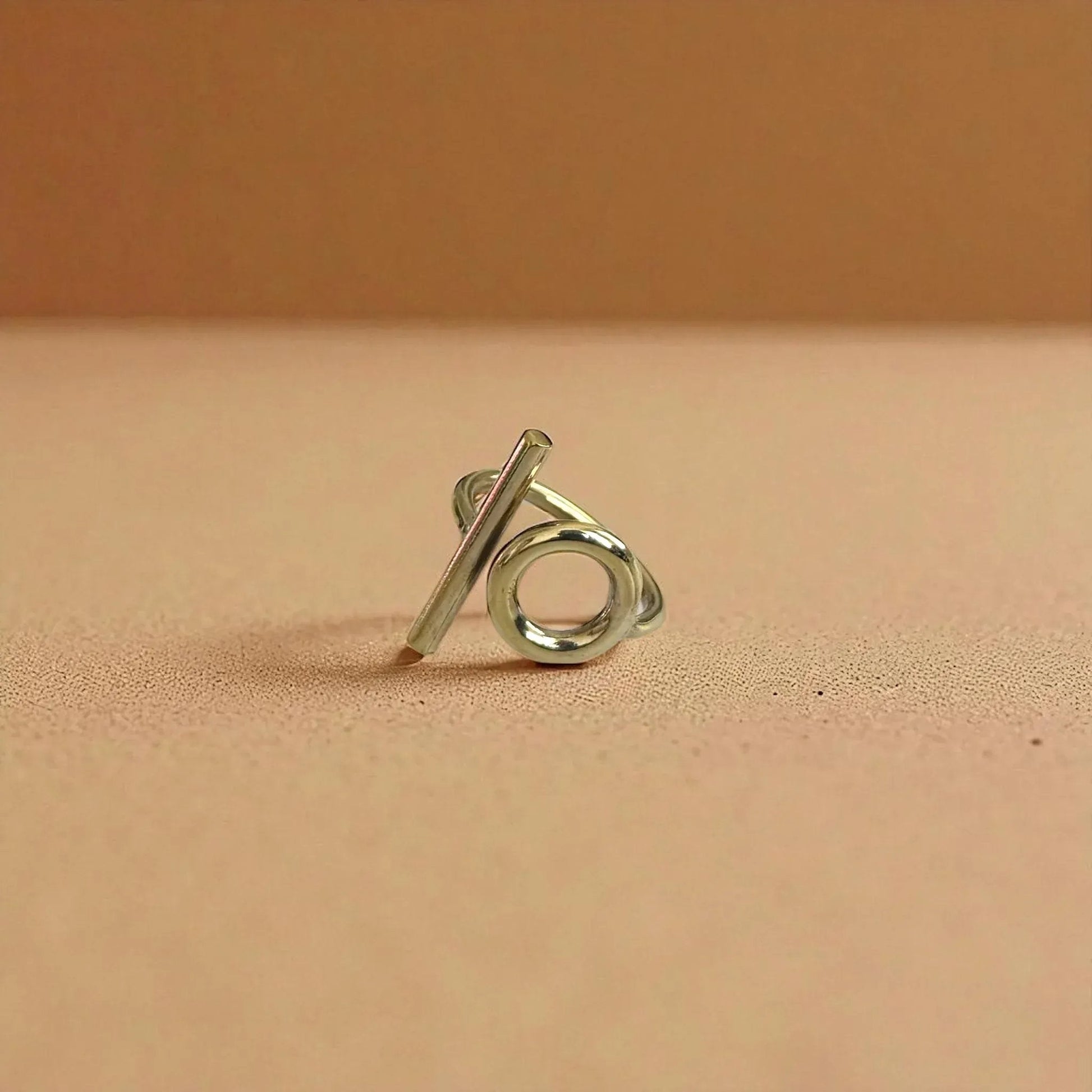 Silver ring with a unique design on a beige background