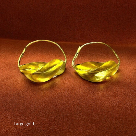 Close-up of the flowing, twisted metalwork on the Jabari earrings, symbolizing bravery and East African heritage.