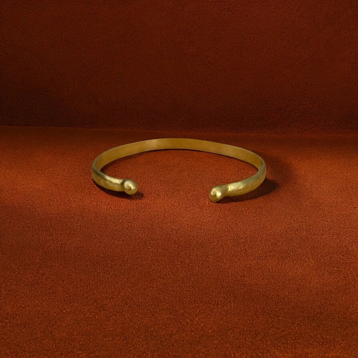 Gold bracelet on a red fabric background