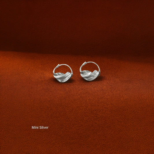 Close-up of the flowing, twisted metalwork on the Jabari earrings, symbolizing bravery and East African heritage.