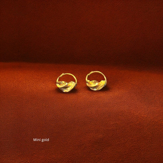 Close-up of the flowing, twisted metalwork on the Jabari earrings, symbolizing bravery and East African heritage.