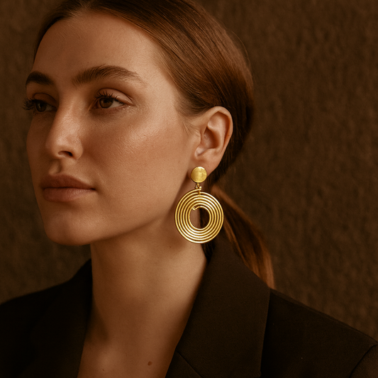 Model wearing the Kolo earrings, showcasing how the spiral form catches the light while remaining bold and refined.