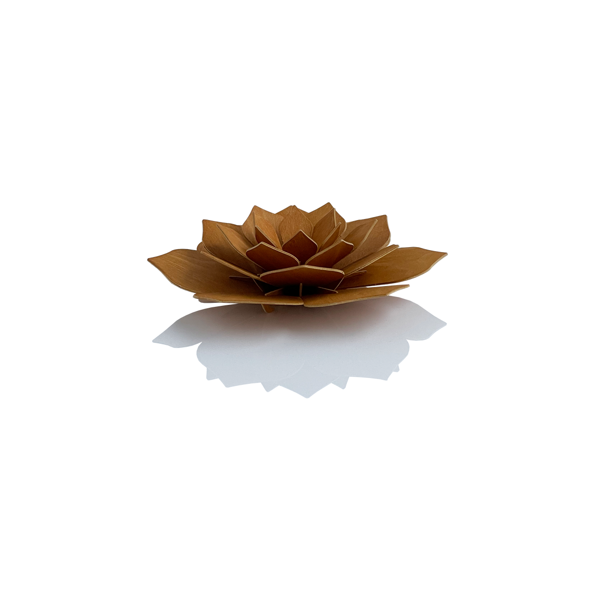 A small sculptural lotus flower made from layered wood veneer in a warm medium brown tone, photographed on a clean white background with a soft reflection underneath.