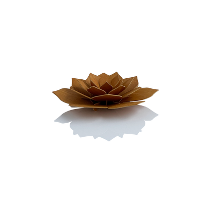 A small sculptural lotus flower made from layered wood veneer in a warm medium brown tone, photographed on a clean white background with a soft reflection underneath.