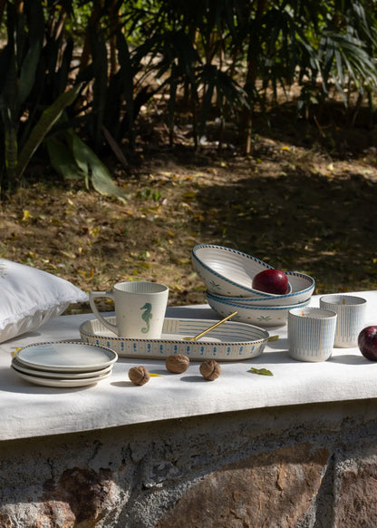 Set of ceramic dishes on a stone surface with a natural background