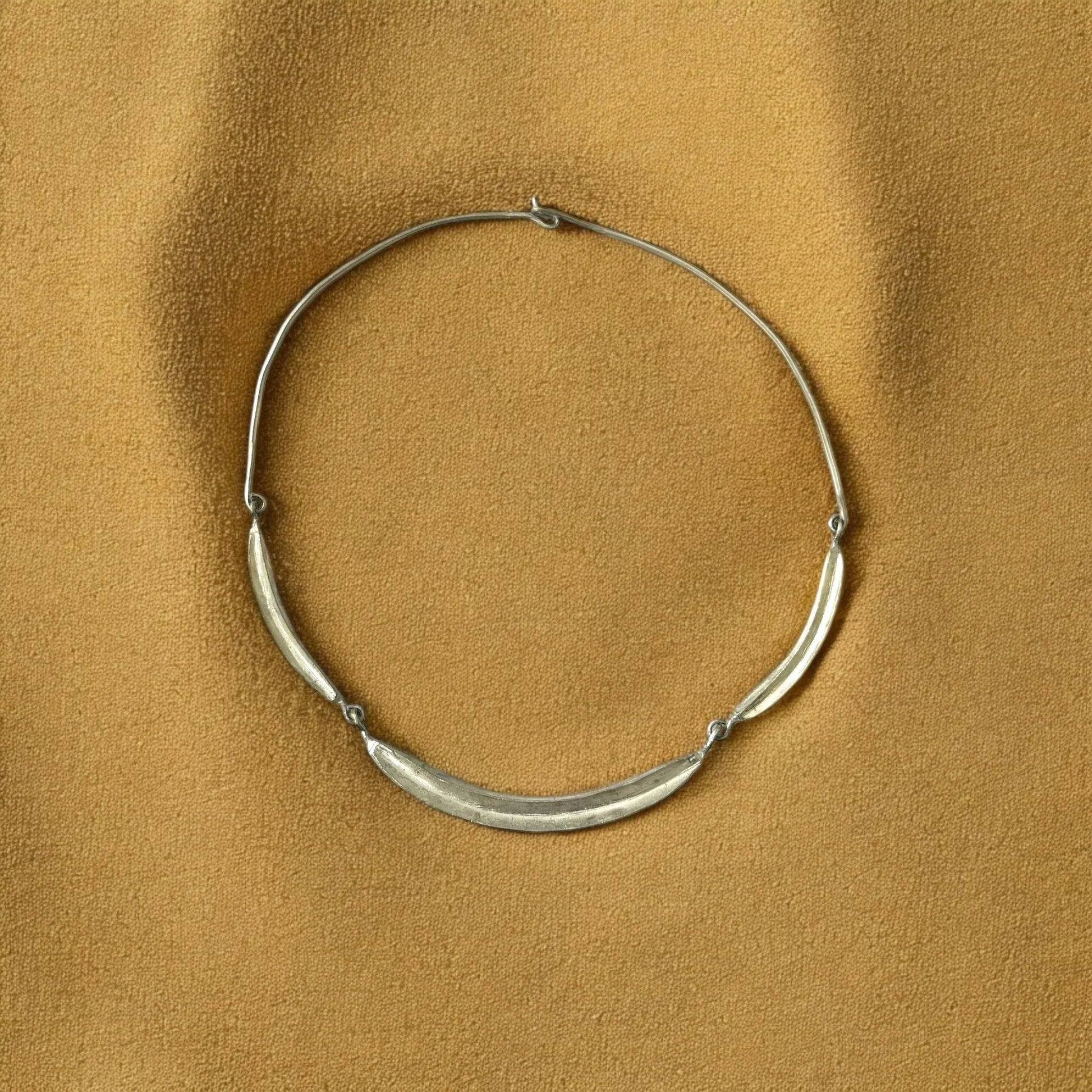 Silver necklace on a brown textured background