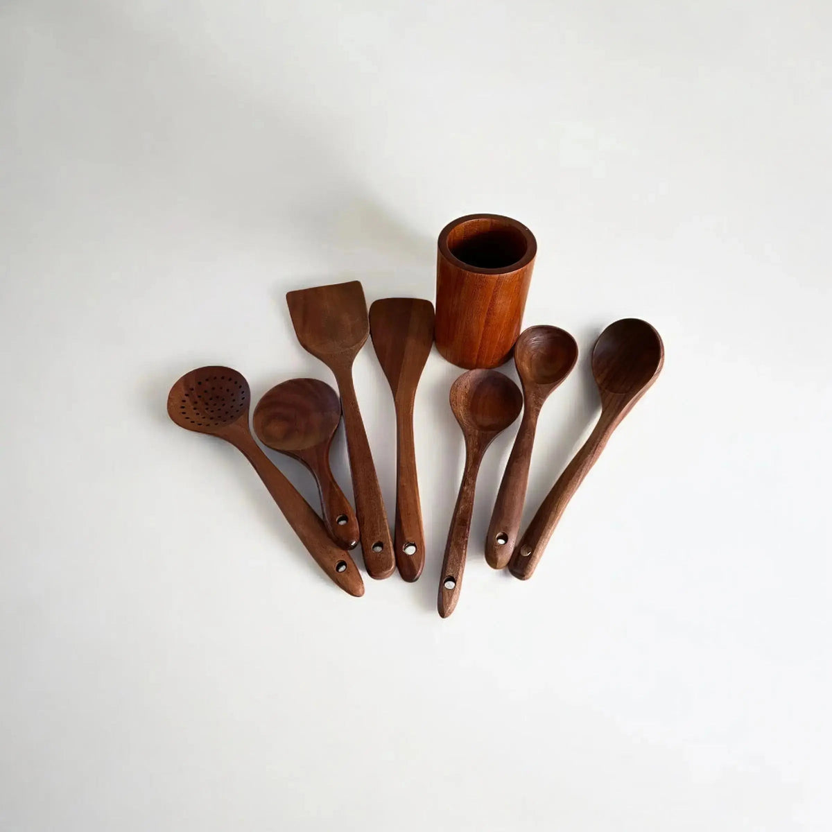 Set of wooden kitchen utensils including spoons and a spatula on a white background