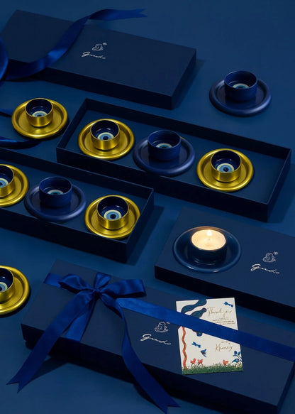 Gorjana jewelry set with blue and gold elements on a matching blue background