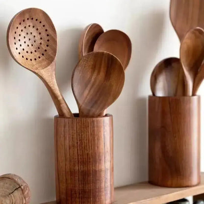 Wooden kitchen utensils in wooden holders on a neutral background