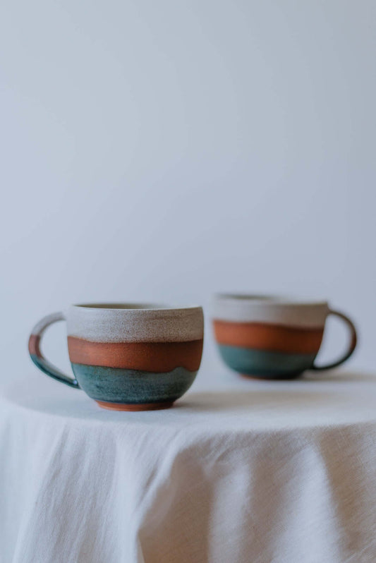 Handcrafted round ceramic cups with a glossy finish, perfect for serving tea, coffee, or other beverages.