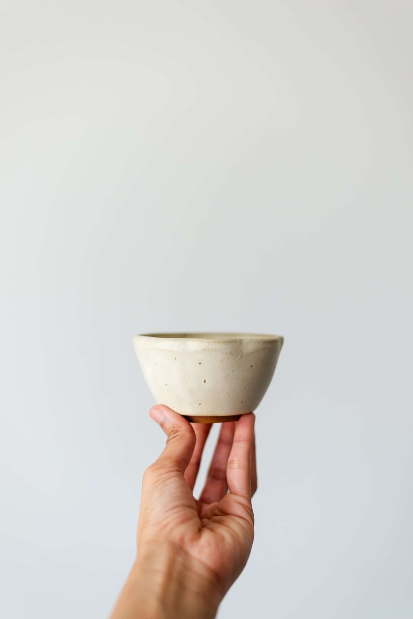 Handcrafted rusty white ceramic dessert bowl with a glossy finish, ideal for serving desserts or snacks.